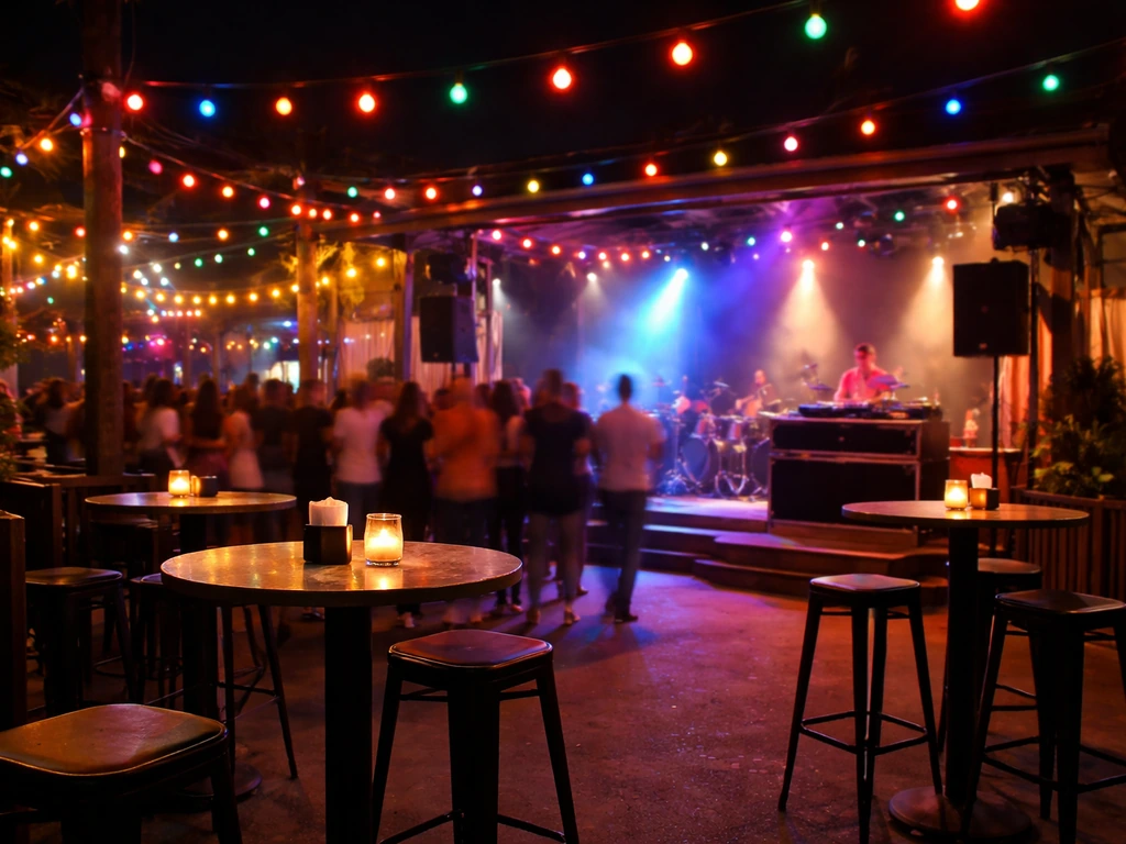 Nighttime patio scene with warm string lights and a visible live stage area, lively nightlife atmosphere.
