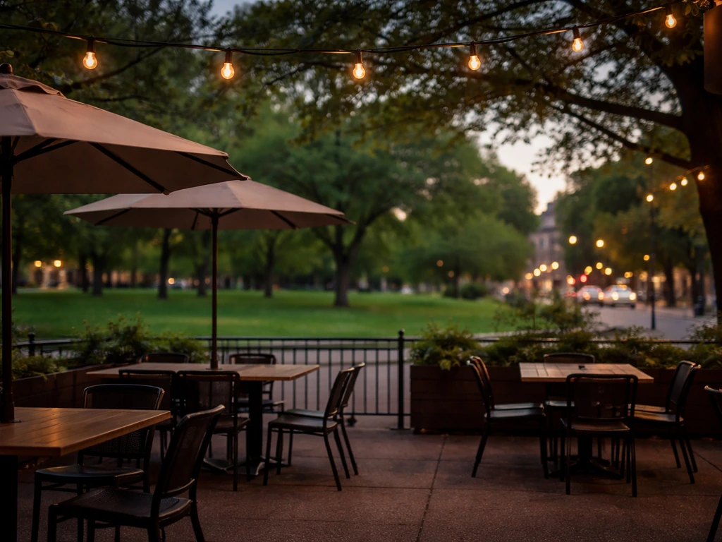 Quiet Lamplighter-style patio with park view, warm evening light contrasting a distant busy street