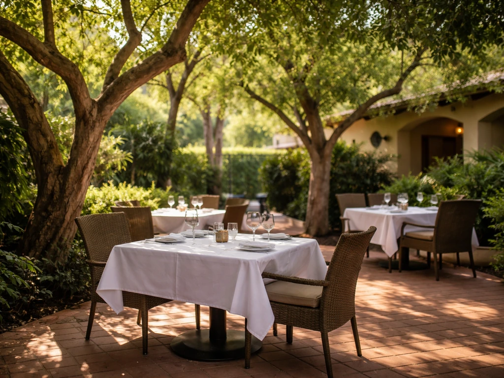 Shaded Spencer’s Restaurant patio with mature trees casting dappled light over neatly set tables.