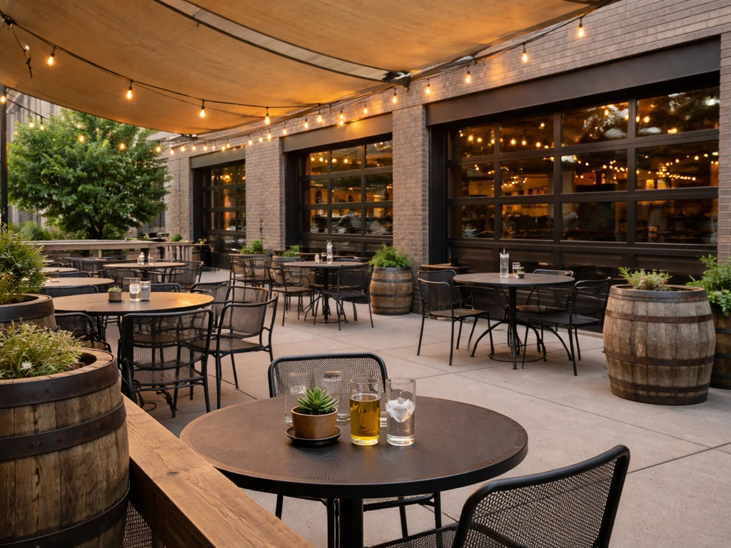 Empty outdoor brewery patio with barrel accents and the downtown WoodGrain-style building behind it