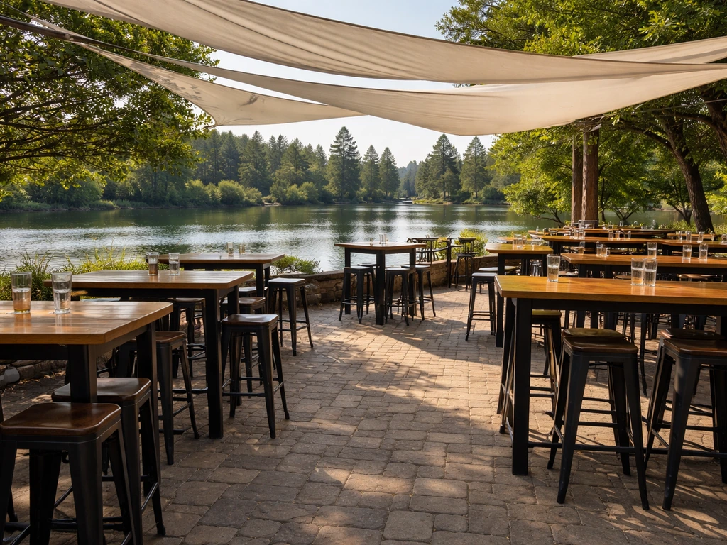 Shaded paver beer garden patio above Mirror Pond in Bend, Oregon with sail covers and standing tables.